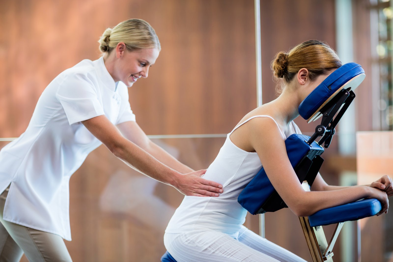 Woman receiving massage in massage chair massage at work