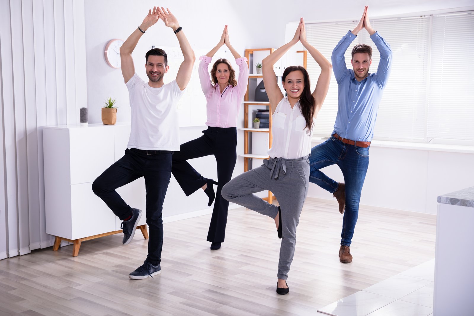Businesspeople Doing Stretching Exercise At Workplace fat loss with exercise